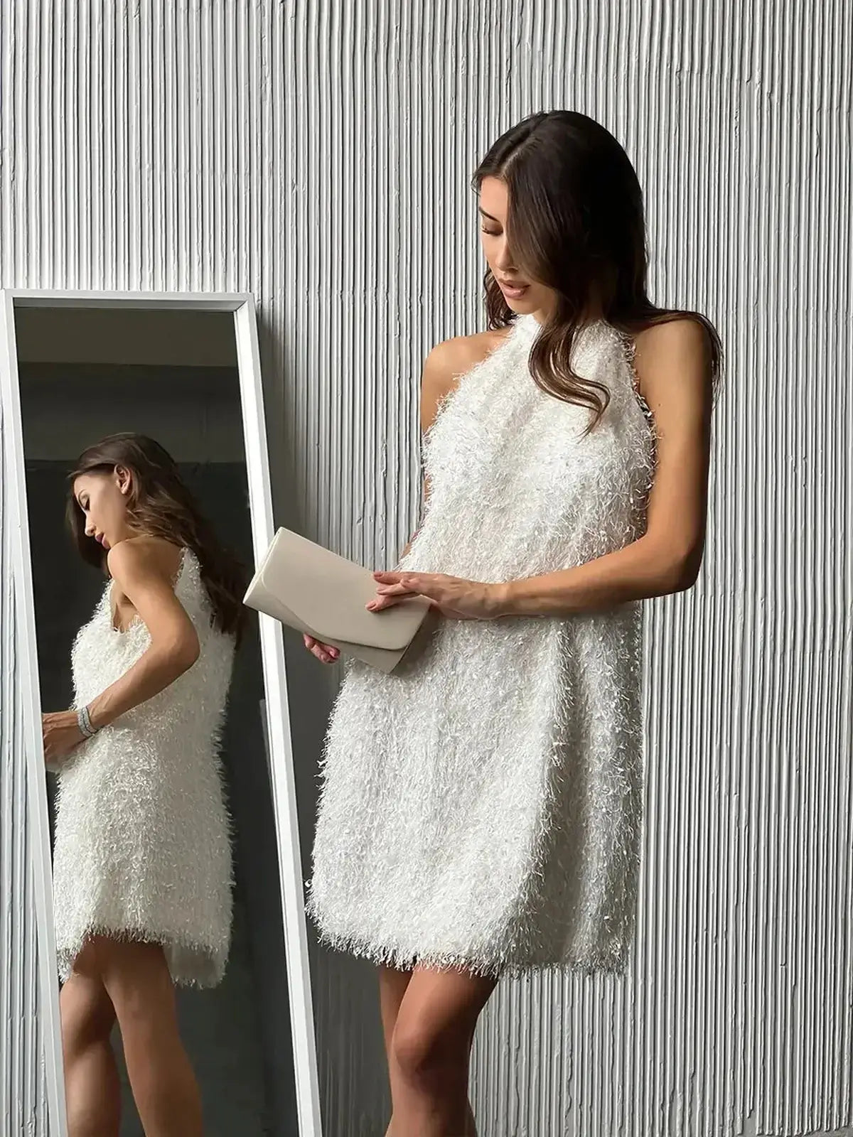 Model in a stylish white Pearl Halo mini dress with textured fringe, perfect for summer parties or wedding guest attire.