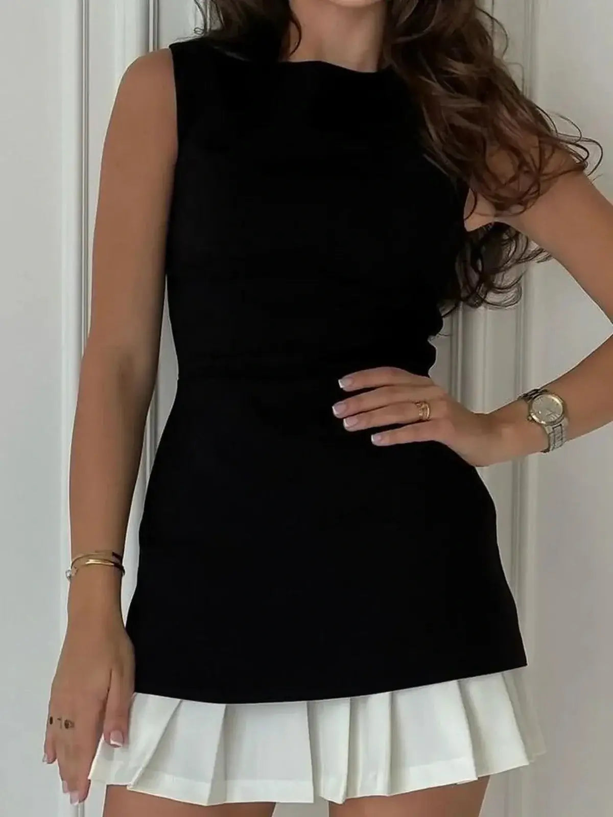 Sculpted black mini dress with a white pleated underlayer, perfect for parties and special occasions.