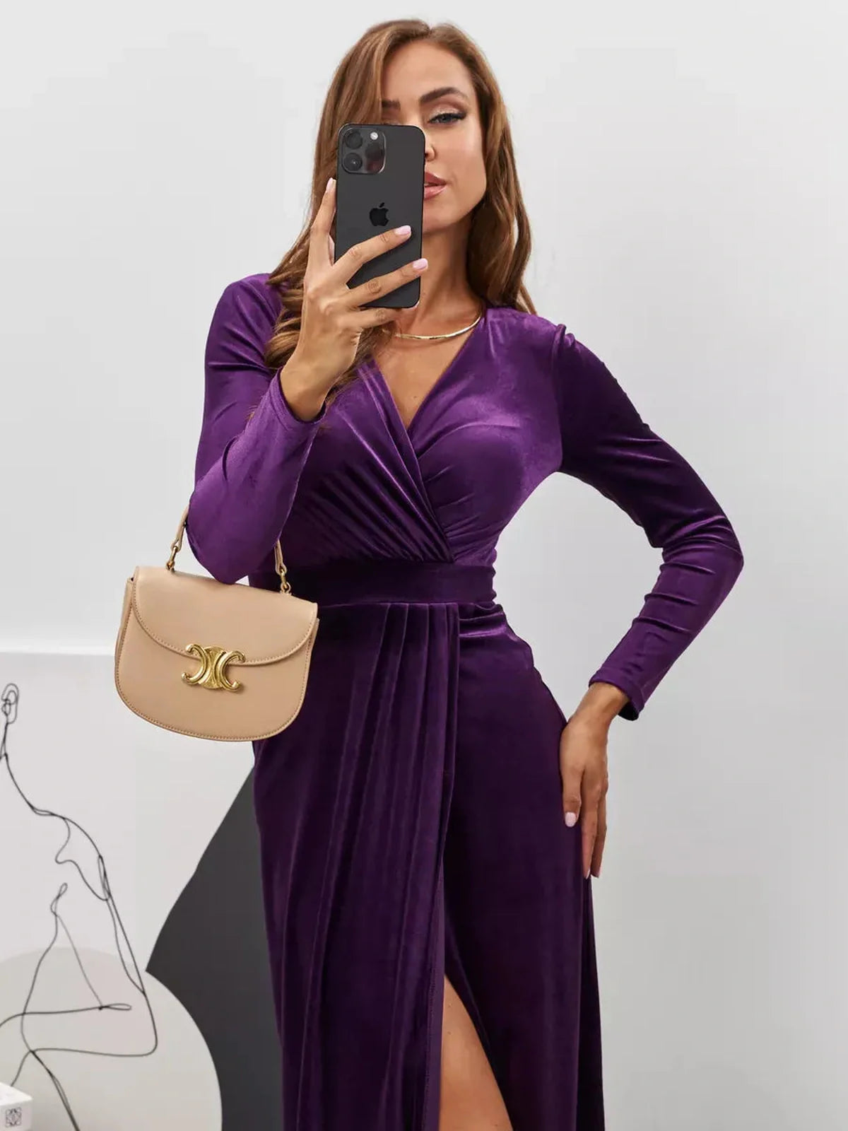 Model showcasing the Plum Aura Maxi Dress in rich velvet with a sultry slit and elegant draped silhouette.