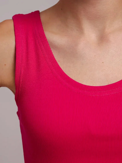 Close-up of a model wearing a fuchsia ribbed tank top, showcasing its sleek and vibrant design.