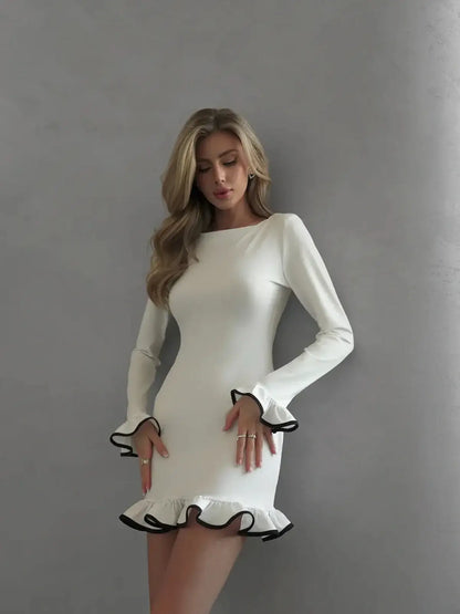 Model wearing a white mini dress with black ruffle trim, perfect for summer and formal occasions.