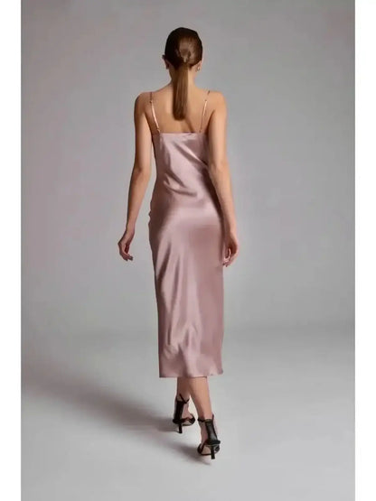 Back view of a woman wearing the Roselle Midi Dress in muted rose satin, showcasing its sleek silhouette.