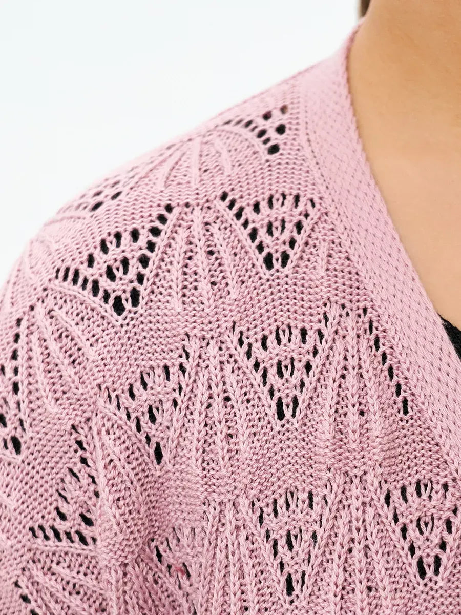 Close-up of a lightweight pink Rosemary Cardigan by Lauven featuring intricate openwork lace patterns.