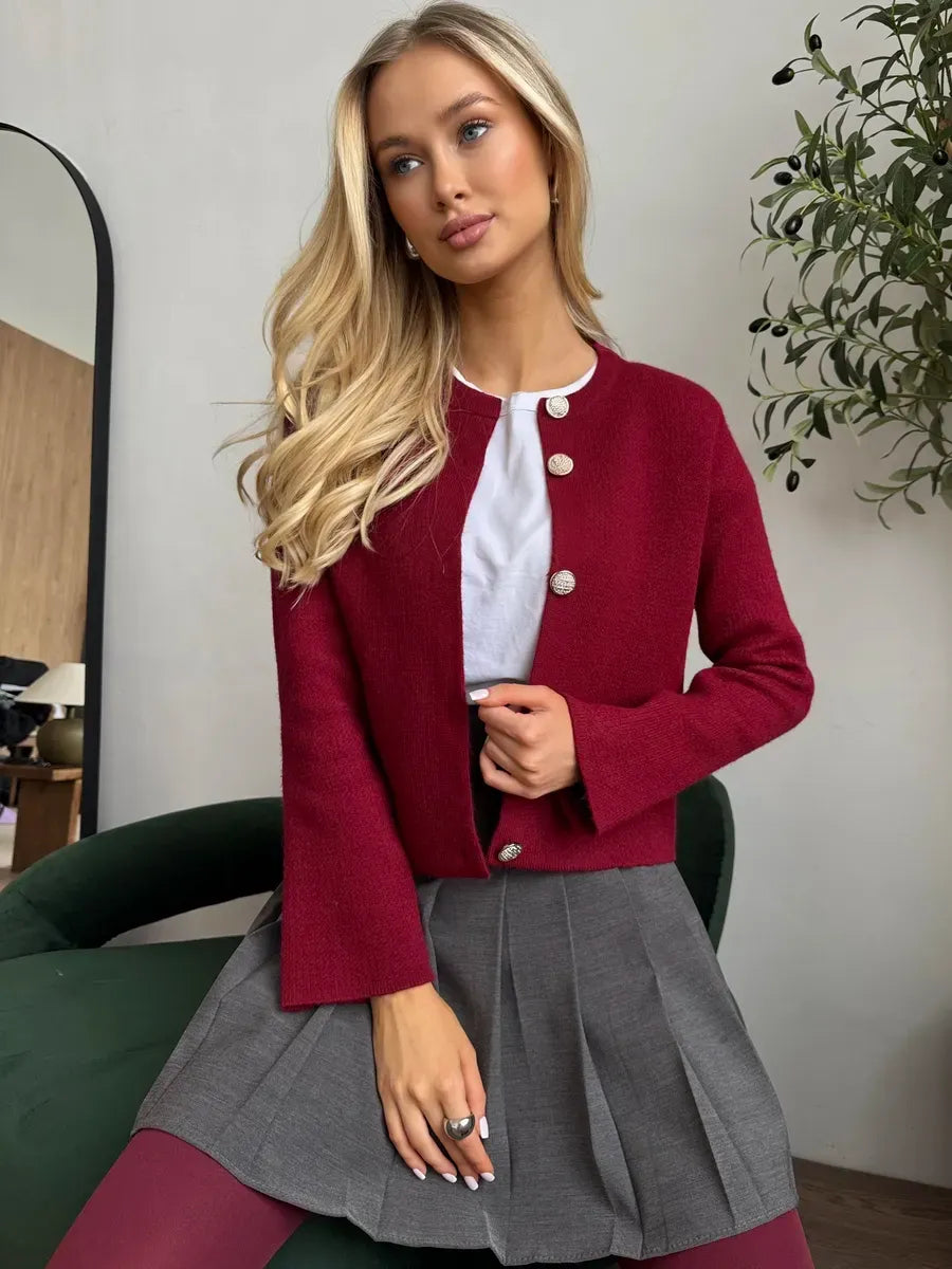 Model wearing Roslyn Cardigan in burgundy with button closure, styled with a skirt, showcasing elegant knitwear from Lauven.