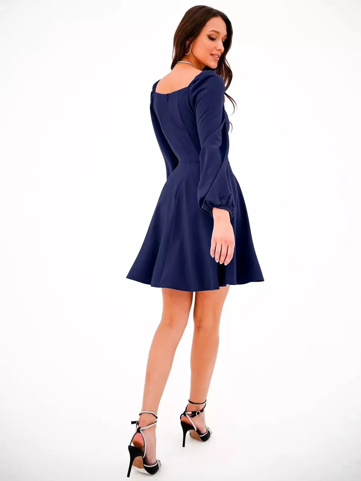Model showing the back of a navy blue long sleeve mini dress, perfect for summer and formal occasions.