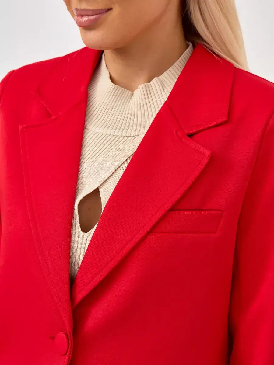 Close-up of a woman wearing a Ruby Blazer by Lauven, showcasing its vibrant red color and tailored design.