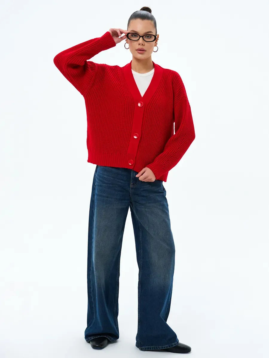 Woman wearing Ruby Cardigan by Lauven, oversized cropped knitwear in vibrant red with button closure.