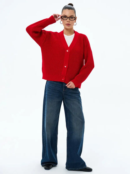 Woman wearing Ruby Cardigan by Lauven, oversized cropped knitwear in vibrant red with button closure.