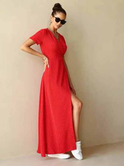 Ruby Grace Maxi Dress in vibrant red polka dots featuring V-neckline, adjustable waist tie, and side slit for ease of movement.