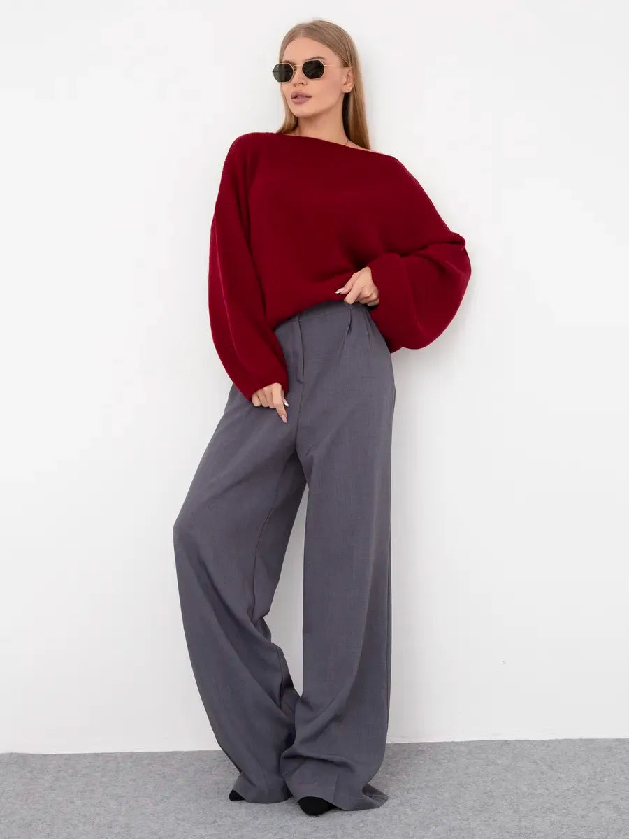 Model wearing Ruby Sweater by Lauven, an oversized knit sweater with a boat neck in deep ruby red.