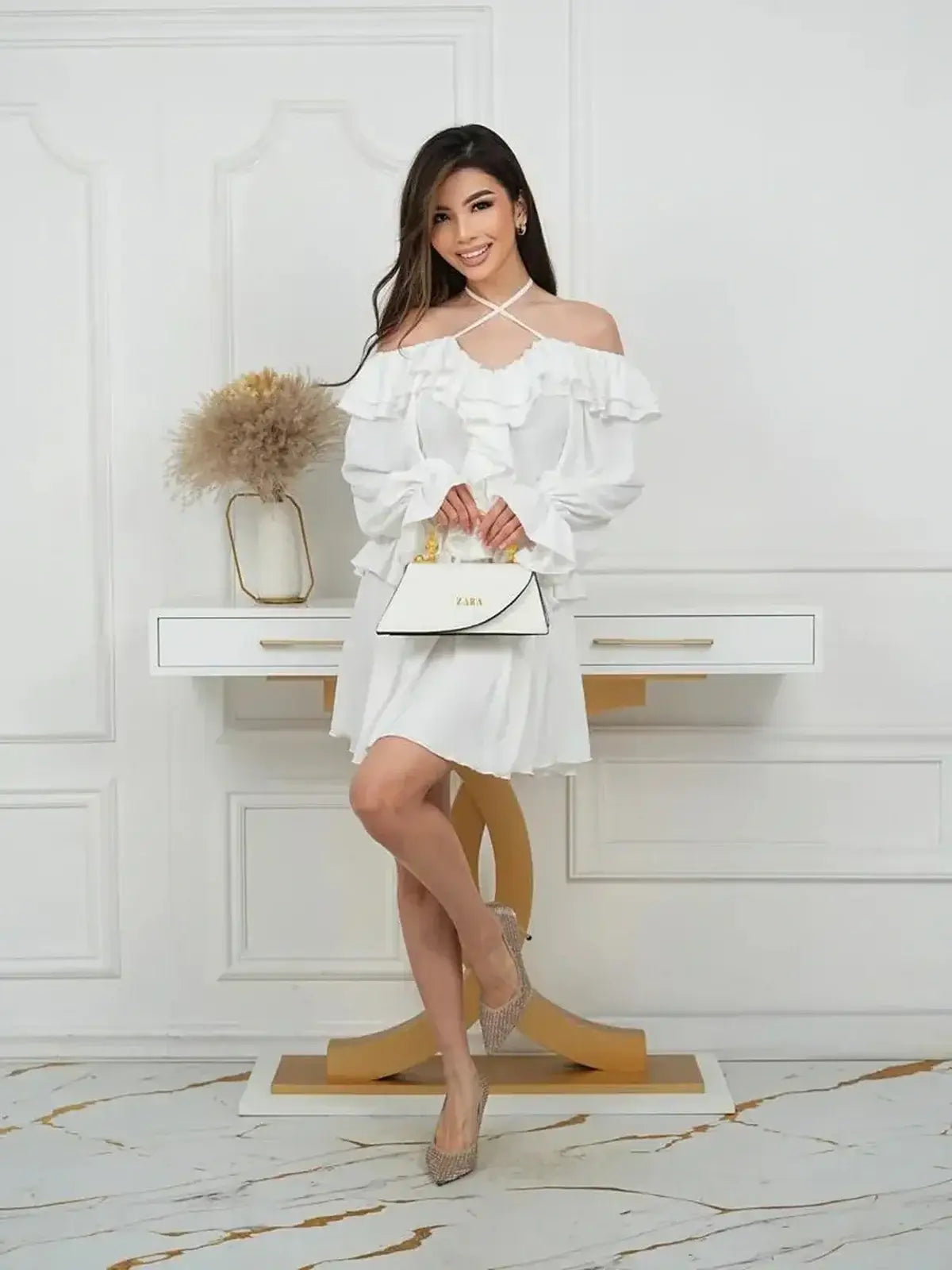 Model showcasing the Ruffle Bloom Mini Dress with romantic ruffles and an off-shoulder neckline.