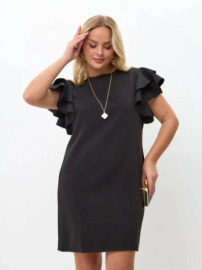 Woman wearing a black mini dress with layered ruffle sleeves, showcasing elegance and style.