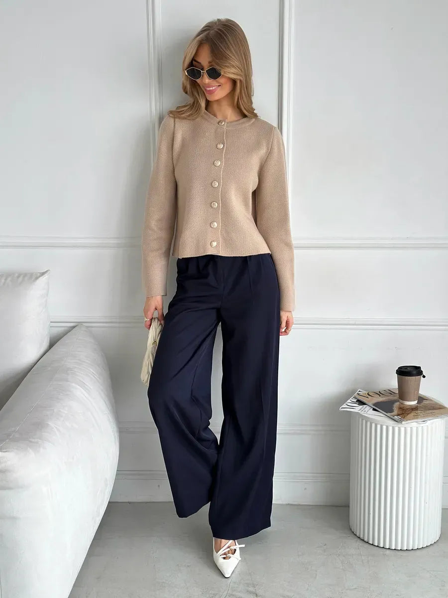 Sable Cardigan by Lauven, elegant cropped knitwear in beige, styled with navy pants and sunglasses.