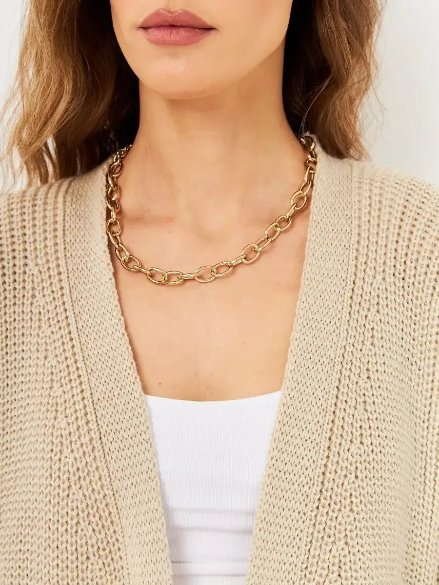 Elegant woman wearing a Sable Cardigan with a gold chain necklace, showcasing stylish autumn knitwear by Lauven.