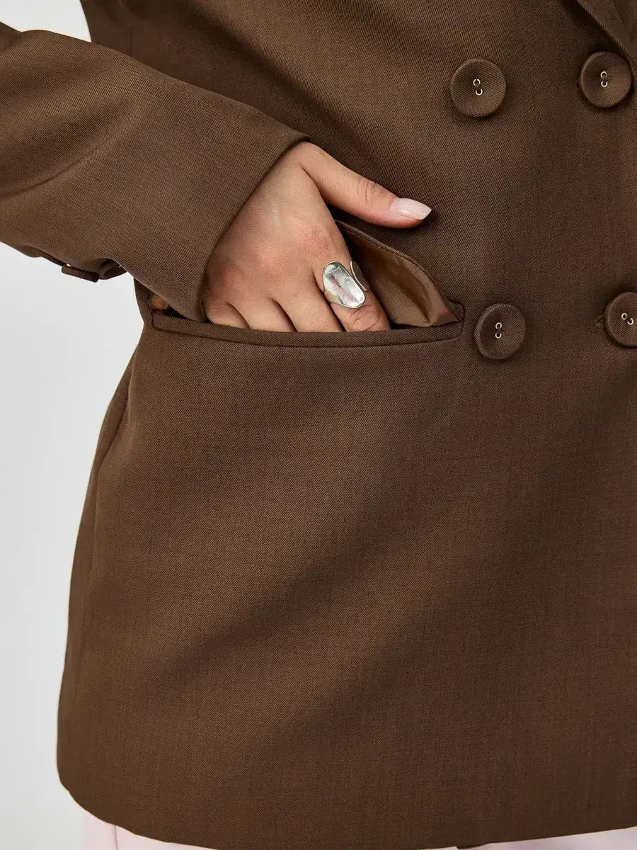 Close-up of the Saffron Blazer by Lauven, showcasing its oversized double-breasted design and stylish pocket.