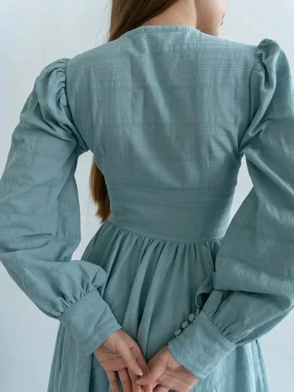 Back view of the Sage Muse Maxi Dress showcasing puff sleeves, a flattering silhouette, and fabric-covered buttons.