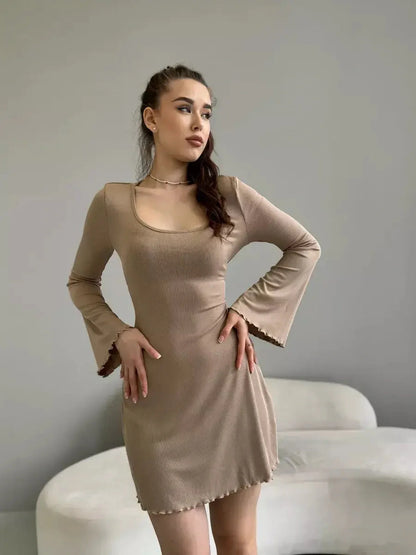 Sahara Glow neutral-tone mini dress with long sleeves and flared cuffs, perfect for summer parties or cocktail events.