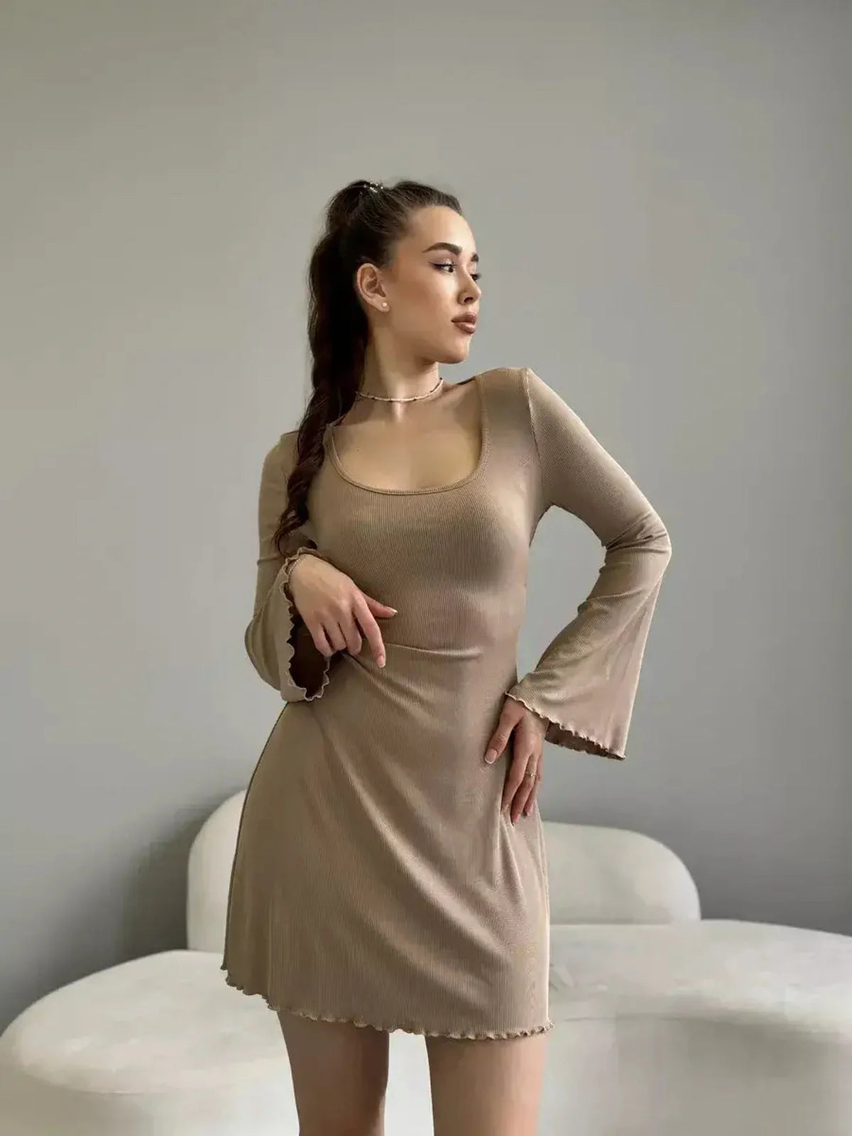 Sahara Glow neutral-tone mini dress showcasing a modern squared neckline and flared sleeves, perfect for summer events.