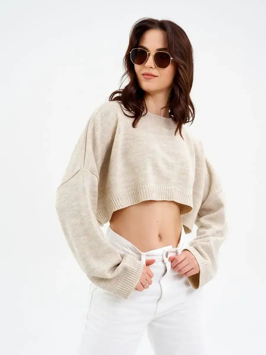 Model wearing the Sand Sweater, a cropped oversized knit in light beige, showcasing modern elegance and comfort.