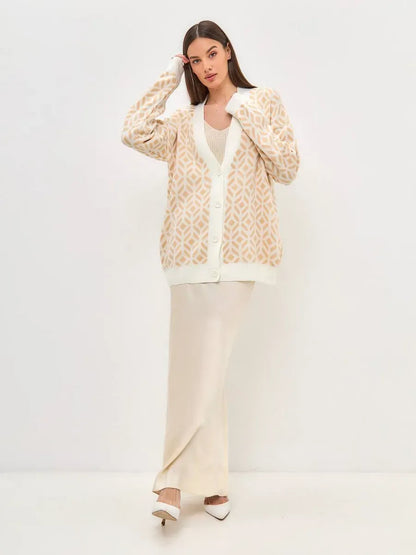 Sandy Cardigan by Lauven, longline acrylic knitwear in soft beige with intricate pattern worn by model.