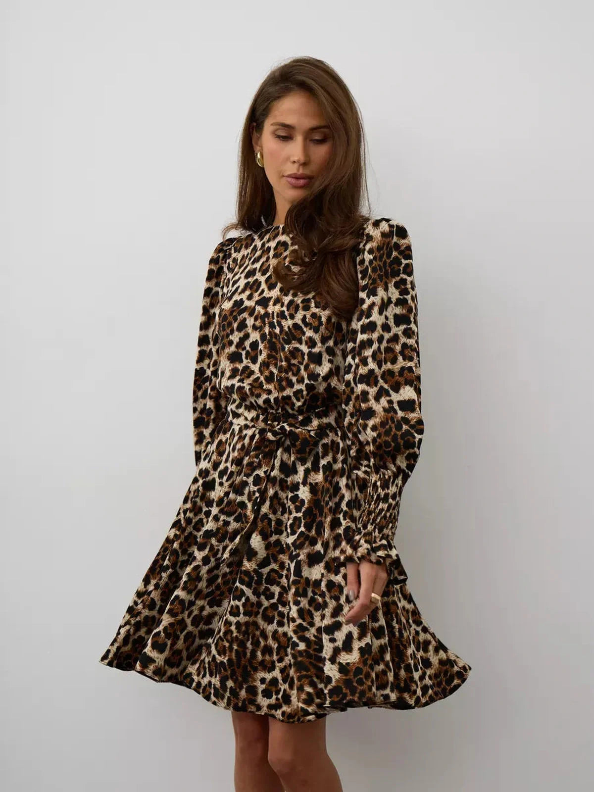 Savannah Mini Dress featuring a bold leopard print, ruffle accents, and a flattering silhouette for a confident look.
