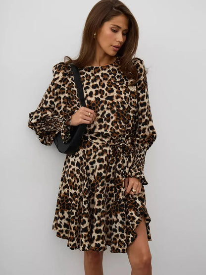 Savannah Mini Dress featuring a bold leopard print, ruffles, and a waist-defining tie belt for an elegant look.