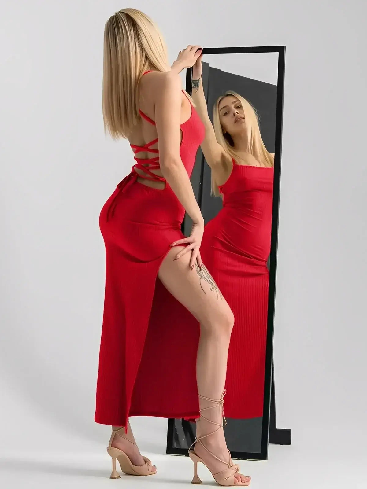 Model showcasing the Scarlet Lace Midi Dress by Lauven, featuring a corset back, side slit, and strappy design.