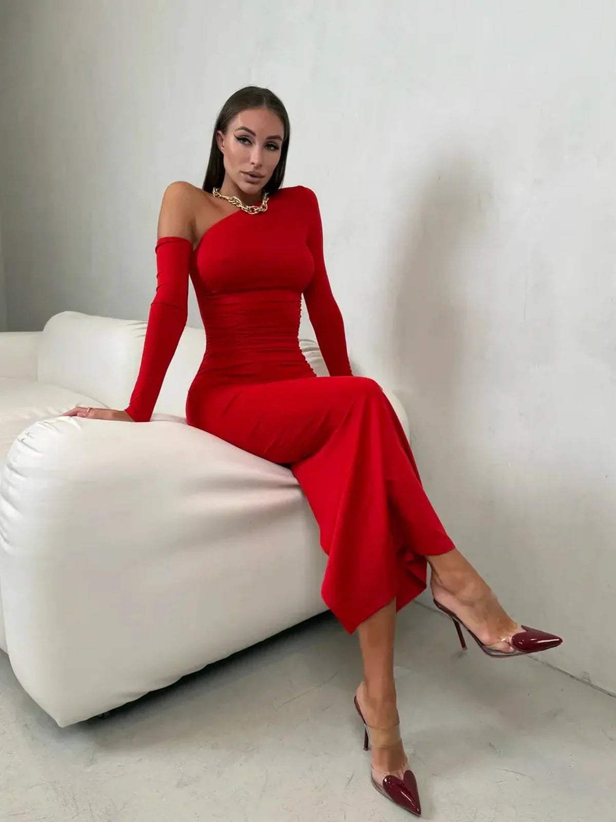 Model showcasing the Scarlet Sculpt Maxi Dress, a bold red one-shoulder gown with elegant draping and stylish heels.