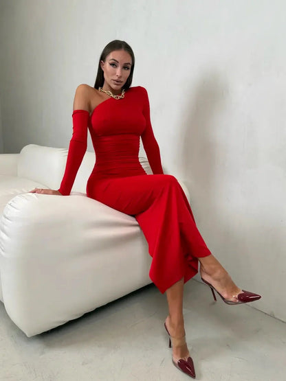 Model showcasing the Scarlet Sculpt Maxi Dress, a bold red one-shoulder gown with elegant draping and stylish heels.