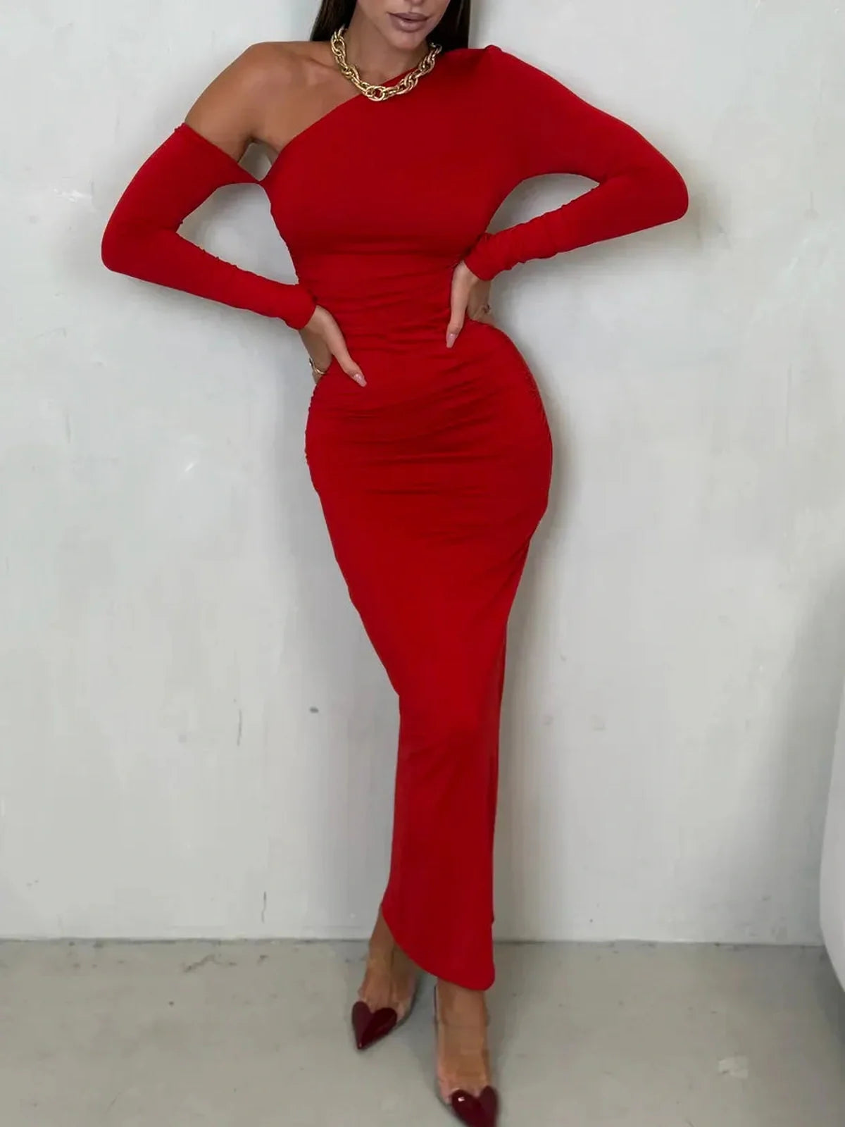 Model wearing a striking scarlet one-shoulder maxi dress with artful draping, exuding elegance and sophistication.