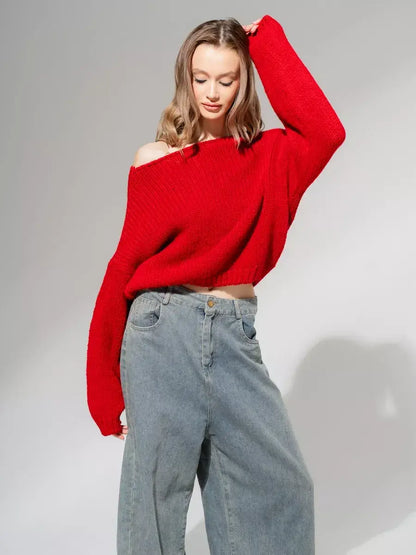 Model showcasing the Lauven Scarlet Sweater, an oversized off-shoulder knit in deep red, paired with relaxed denim.