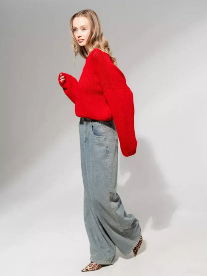 Oversized off-shoulder Scarlet Sweater by Lauven in deep red, paired with wide-leg jeans and stylish pointed shoes.