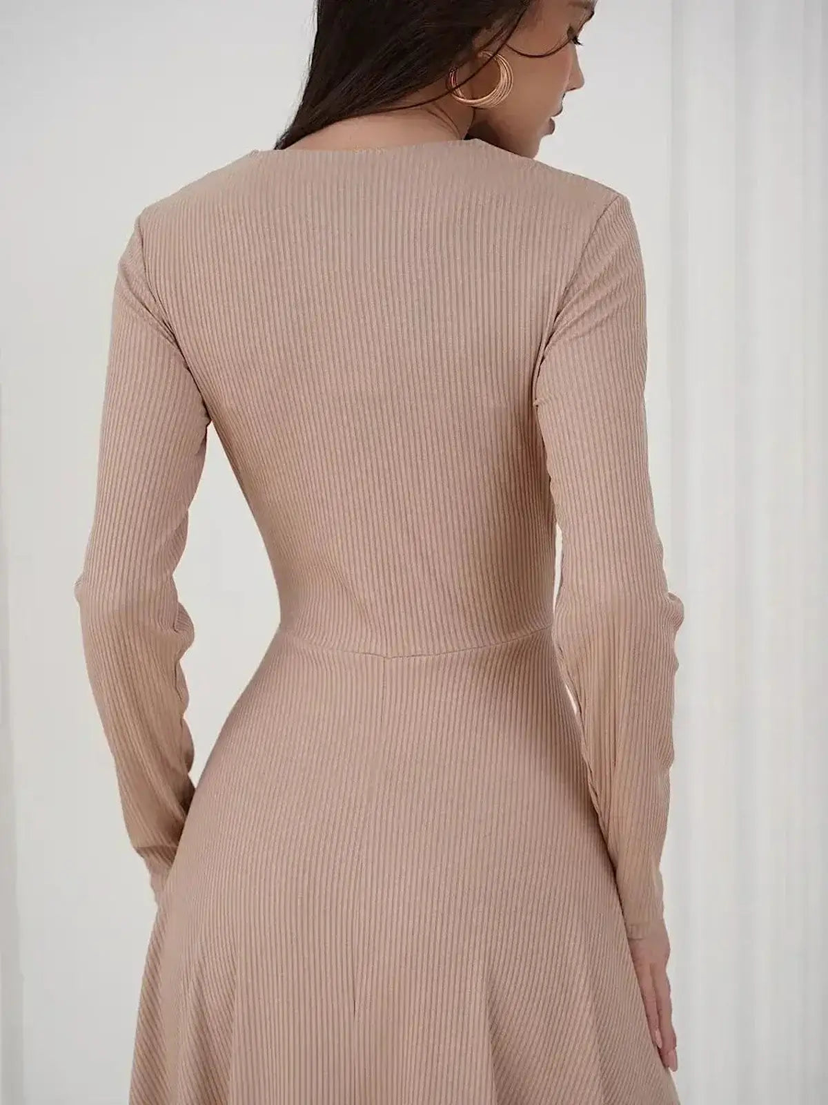 Back view of a woman wearing the Sculpted Ease Midi Dress by Lauven in a smooth beige ribbed knit.