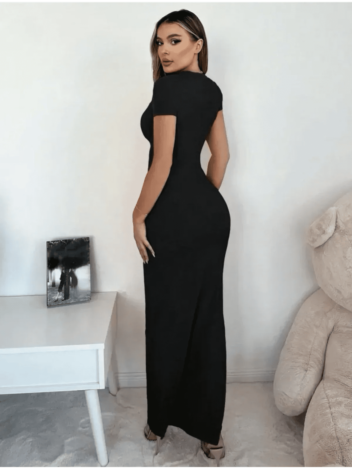 Model showcasing the Sculpted Elegance Maxi Dress, featuring a sleek fit and V-neckline in a minimalist black design.