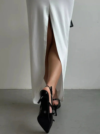 Sculpted Glow Maxi Dress featuring a thigh-high slit and elegant black strappy heels, showcasing sophisticated summer style.