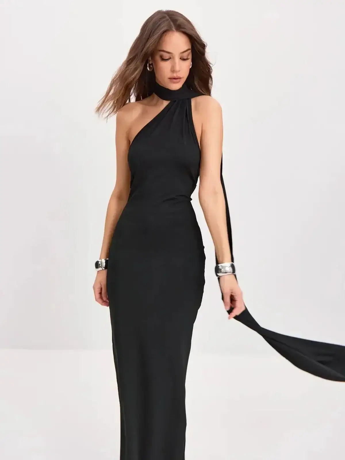 Model wearing the Sculpted Grace Maxi Dress, showcasing a sleek one-shoulder design and dramatic scarf-tie detail.