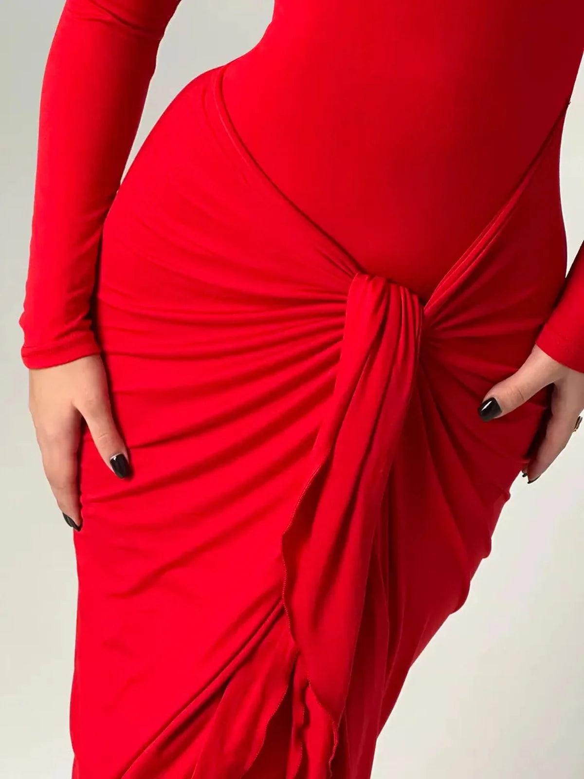 Close-up of Sculpted Grace Maxi Dress showcasing luxurious red fabric with elegant knotted waist detail.