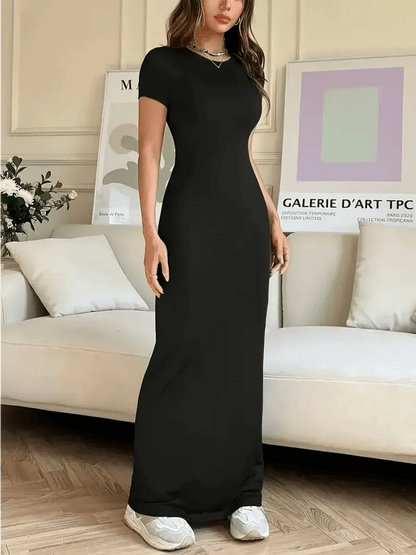 Sculpted Grace Maxi Dress in black, showcasing a sleek silhouette against a modern, stylish interior.