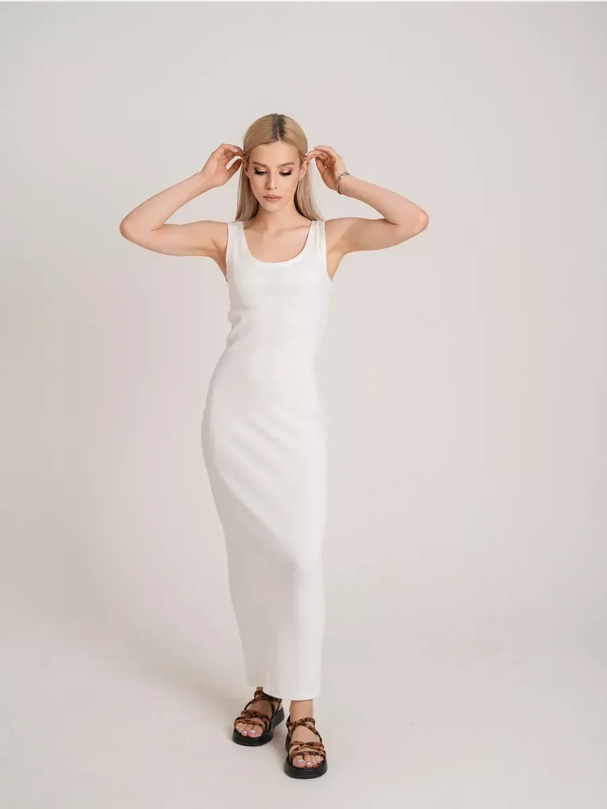 Model wearing the Sculptura Maxi Dress featuring a sleek white ribbed design, perfect for warm weather.
