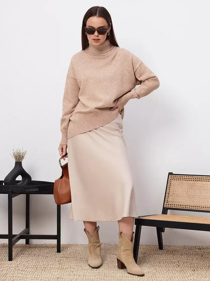Selene Sweater by Lauven in dark beige, styled with a silk skirt and boots, perfect for modern fashion.