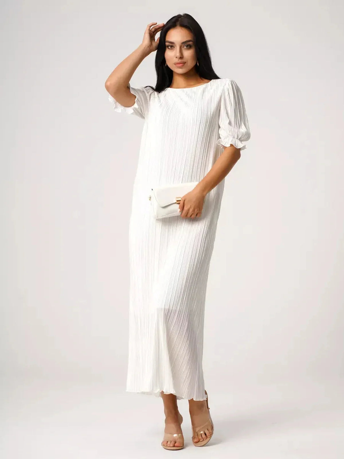 Elegant woman in a pleated white Seraphine Maxi Dress, perfect for summer events, showcasing refined style and comfort.