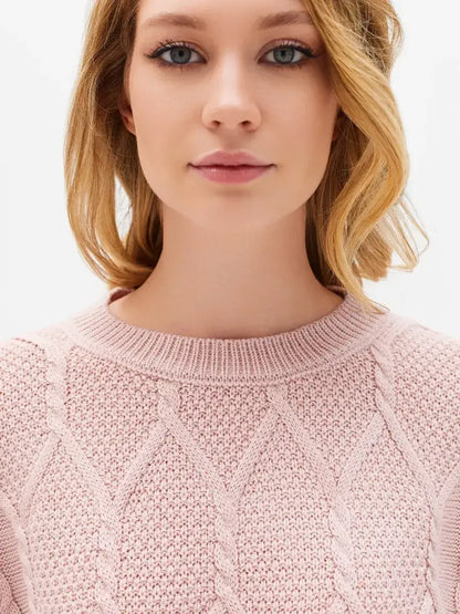 Model wearing the Lauven Seren Sweater in powder pink, showcasing its stylish cable knit design.