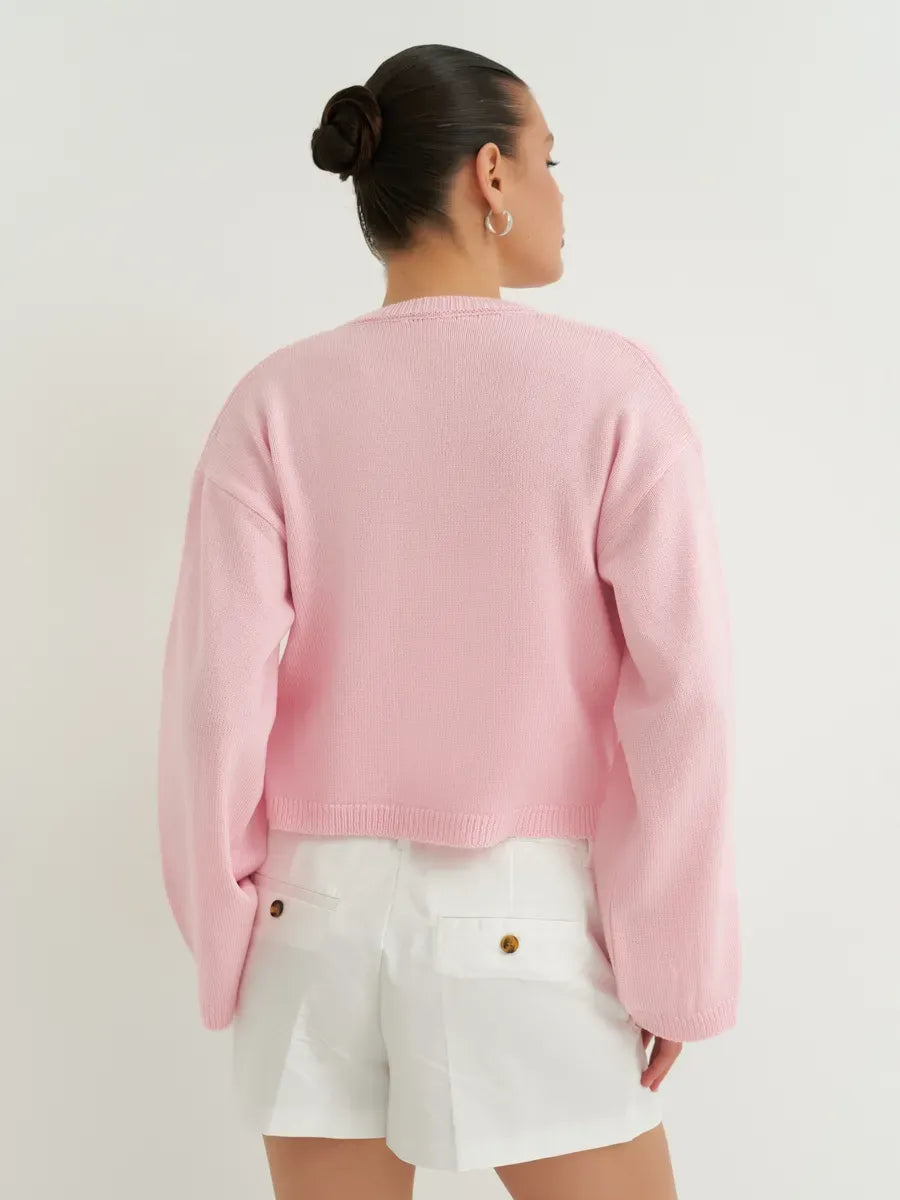 Back view of a model wearing the lightweight Serena Cardigan from Lauven in soft powder pink.