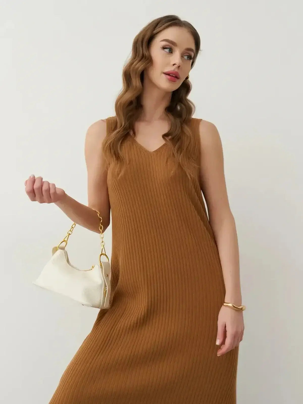 Serena Maxi Dress in ribbed knit, sleeveless silhouette with V-neckline, styled with a white handbag.