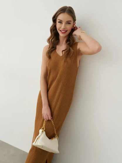Model wearing a Serena Maxi Dress in ribbed knit, featuring a V-neckline and carrying a stylish handbag.