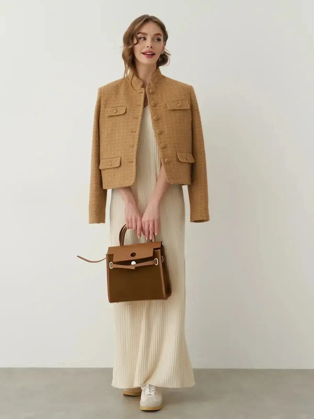 Model wearing a chic kimono jacket over a ribbed maxi dress, styled with a handbag and sneakers for a modern look.