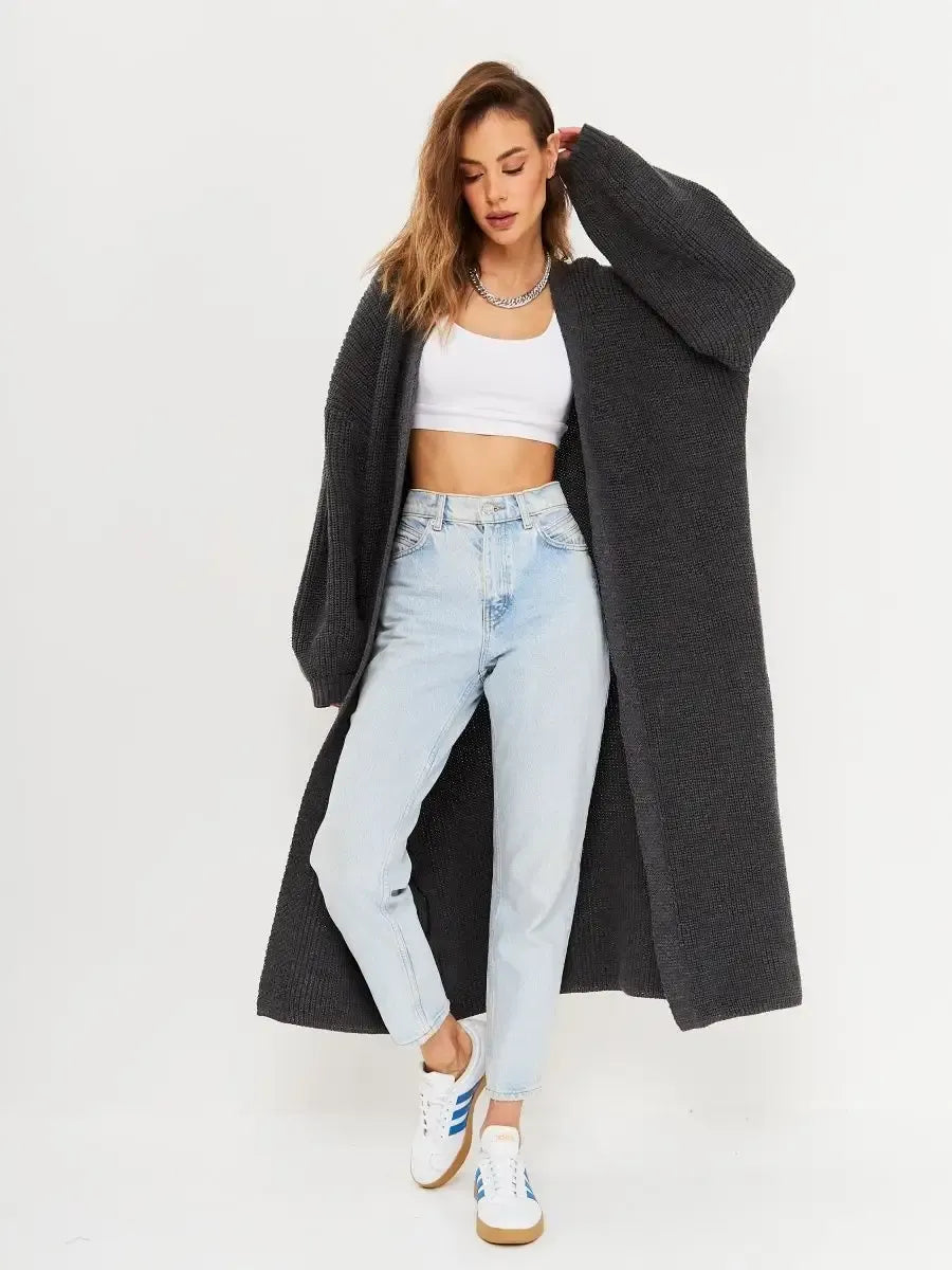 Model wearing Shadow Cardigan by Lauven, an oversized knitwear coat in deep gray, styled with light blue jeans.