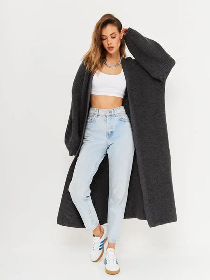 Model wearing Shadow Cardigan by Lauven, an oversized knitwear coat in deep gray, styled with light blue jeans.