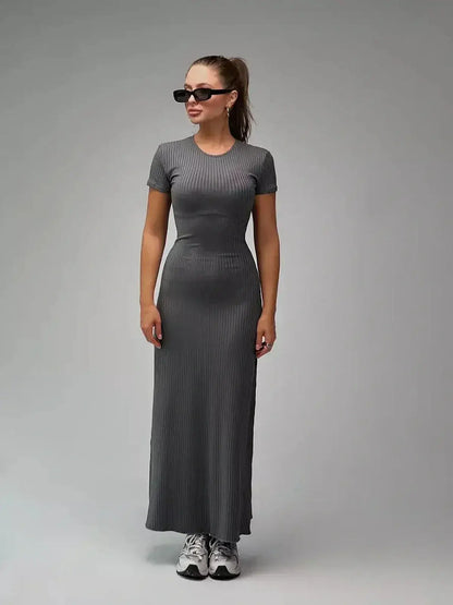 Model wearing the Shadow Curve Maxi Dress in a sleek gray ribbed knit, perfect for summer or casual occasions.