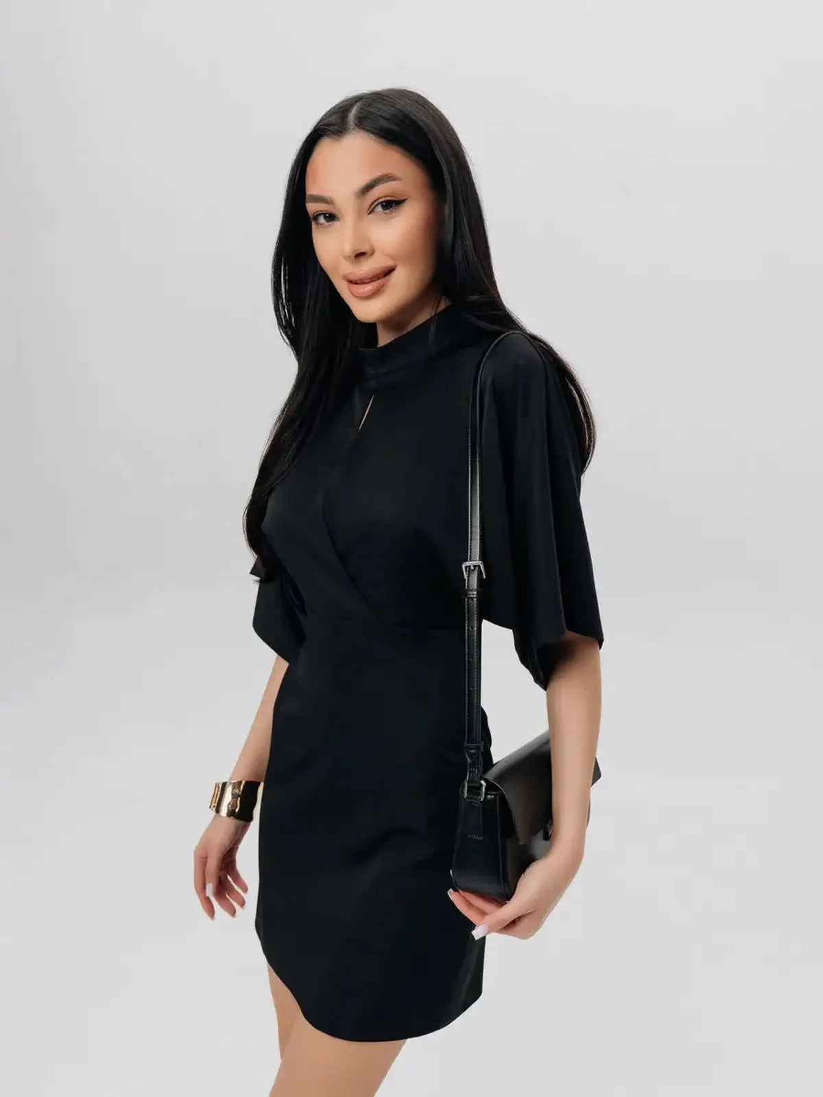 Model wearing the Shadow Grace black mini dress with winged short sleeves, perfect for weddings or parties.